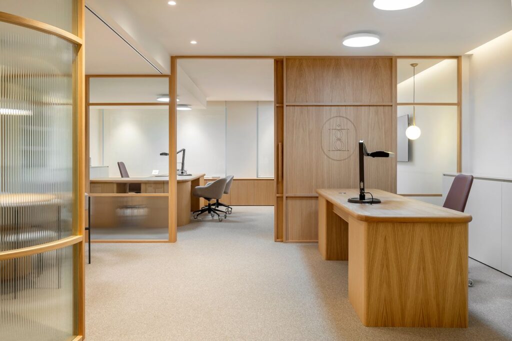 Sleek modern office with wooden furniture in Barcelona, featuring bright lighting and open space.